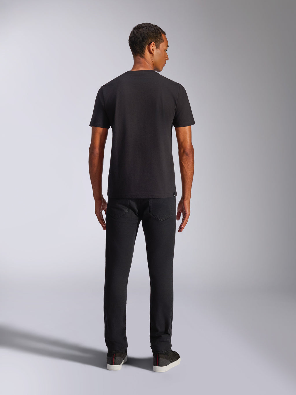 Alpinestars Shaded CSF Tee, maglietta a maniche corte, nero, vista posteriore su modello che indossa pantaloni neri, streetwear casual ispirato al motorsport