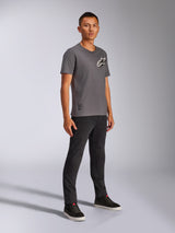 Alpinestars Shaded CSF Tee, t-shirt a maniche corte, grigio carbone, indossata da un modello uomo con pantaloni neri e sneakers scure, caratterizzata dal logo Astars inclinato bianco e nero, streetwear casual ispirato al motorsport