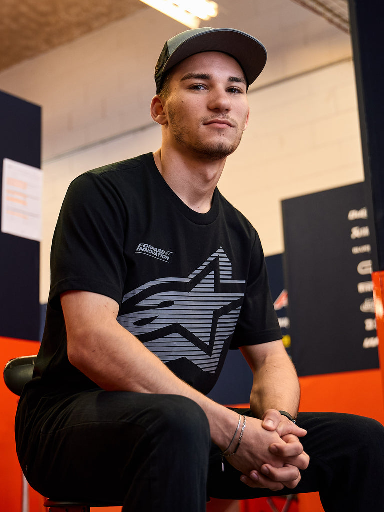 Alpinestars Fasting CSF Tee, t-shirt a maniche corte, nero, grande logo a stella geometrico grigio con testo Forward Innovation, indossata da un uomo in un contesto casual motorsport, abbigliamento sportivo Lifestyle