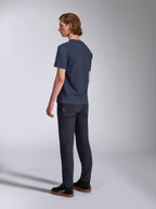 Alpinestars Fasting CSF Tee, T-shirt a maniche corte, blu navy, vista posteriore su modello, abbinata a pantaloni in denim scuro e sneakers nere, streetwear casual ispirato al motorsport