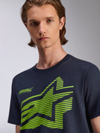 T-shirt Alpinestars Fasting CSF, maglietta a maniche corte, blu navy, grafica a stella geometrica verde lime con scritta Forward Innovation, indossata da un modello, abbigliamento streetwear casual motorsport