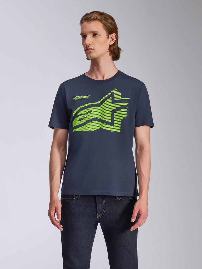 Alpinestars Fasting CSF Tee, t-shirt a maniche corte, blu navy, grande logo Astars geometrico verde lime, indossata da un modello con jeans scuri, streetwear casual motorsport