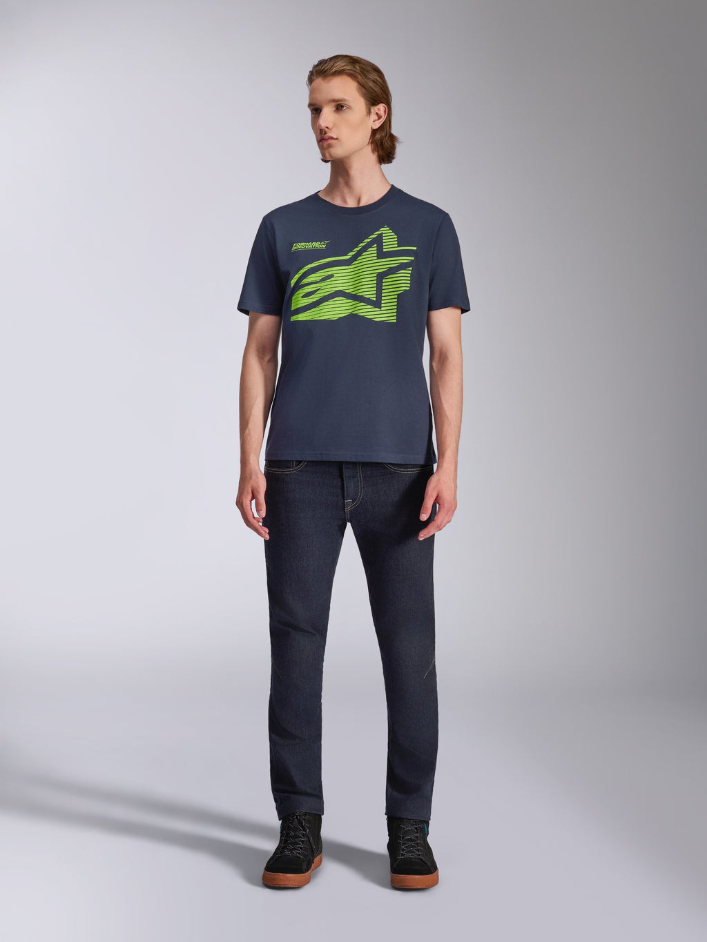 Alpinestars Fasting CSF Tee, maglietta a maniche corte, blu navy con logo geometrico Astars verde lime, abbigliamento casual motorsport streetwear, indossata con jeans scuri