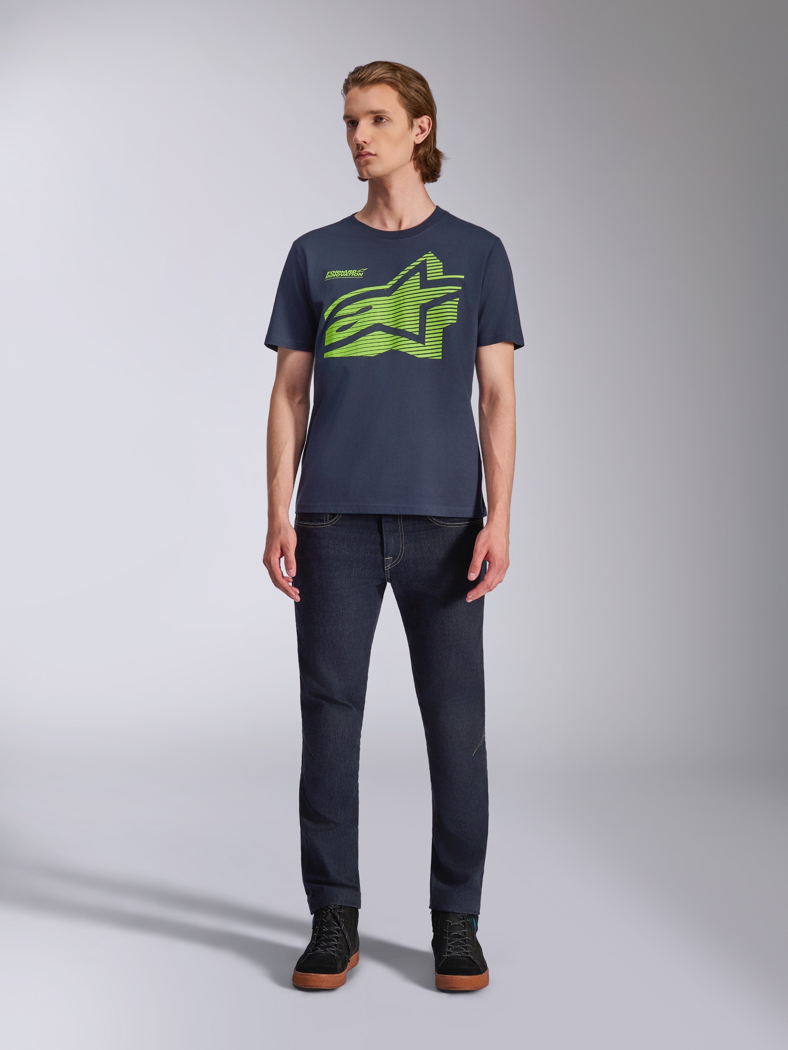 Alpinestars Fasting CSF Tee, maglietta a maniche corte, blu navy con logo geometrico Astars verde lime, abbigliamento casual motorsport streetwear, indossata con jeans scuri