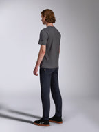 Alpinestars Waving CSF Tee, t-shirt a maniche corte, charcoal, vista posteriore su modello, piccolo logo a stella nero sulla manica, indossata con jeans in denim scuro e sneakers nere, streetwear casual motorsport