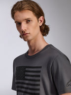 Alpinestars Waving CSF Tee, t-shirt a maniche corte, antracite, con grafica a bandiera nera effetto consumato e piccoli loghi a stella, abbigliamento sportivo casual da uomo