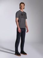 Alpinestars Waving CSF Tee, maglietta a maniche corte, antracite, grafica con bandiera ondulata nera, indossata da un modello con jeans scuri e sneakers, abbigliamento streetwear casual motorsport