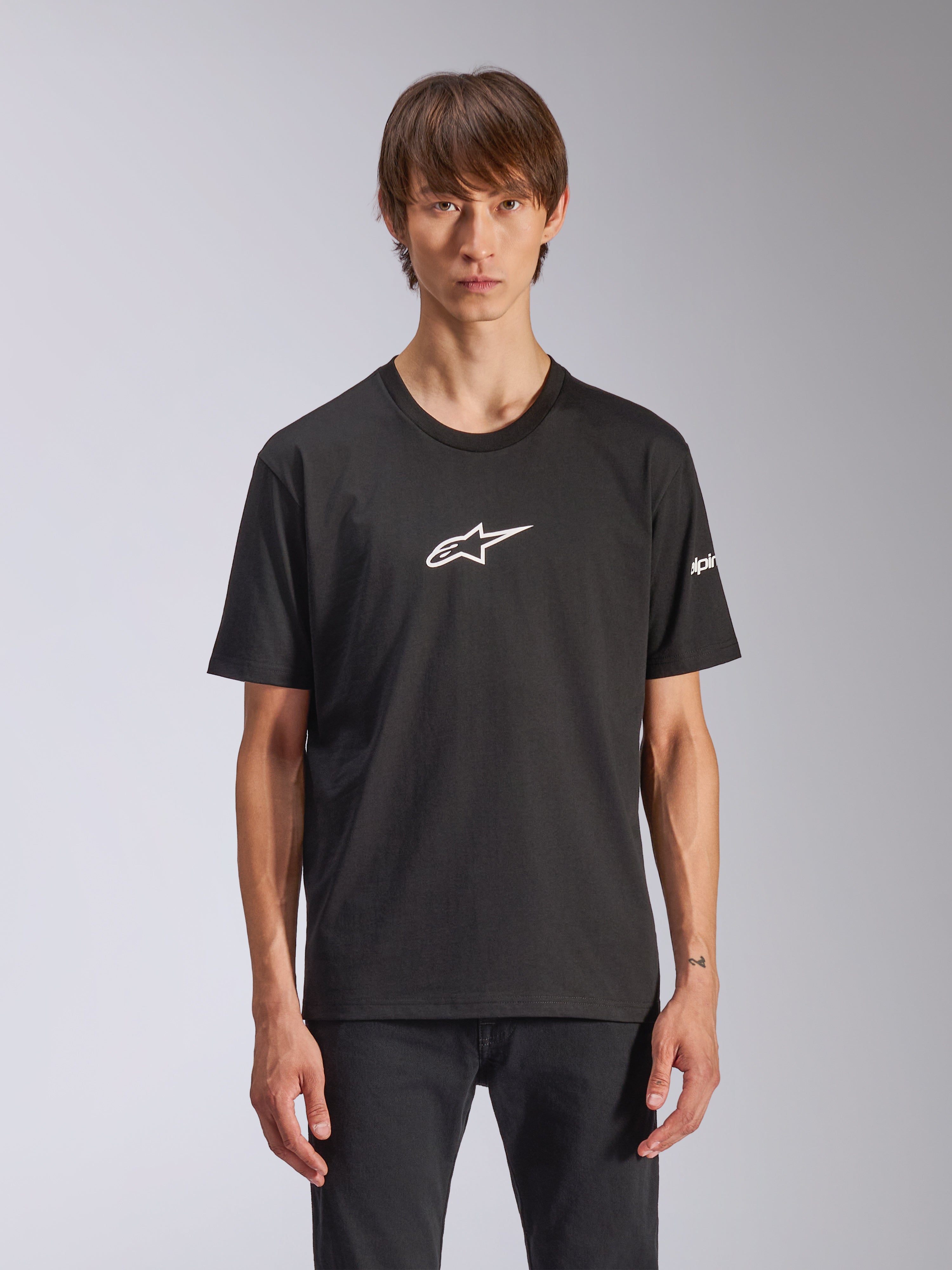Alpinestars Frontal CSF Tee, maglietta a maniche corte nera con logo Astars bianco sul petto, indossata da un modello, abbigliamento motorsport casual
