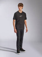 Alpinestars Frontal CSF Tee, t-shirt a maniche corte, nera, logo Astars bianco sul petto, indossata da un modello con jeans scuri e sneakers nere, streetwear casual performante