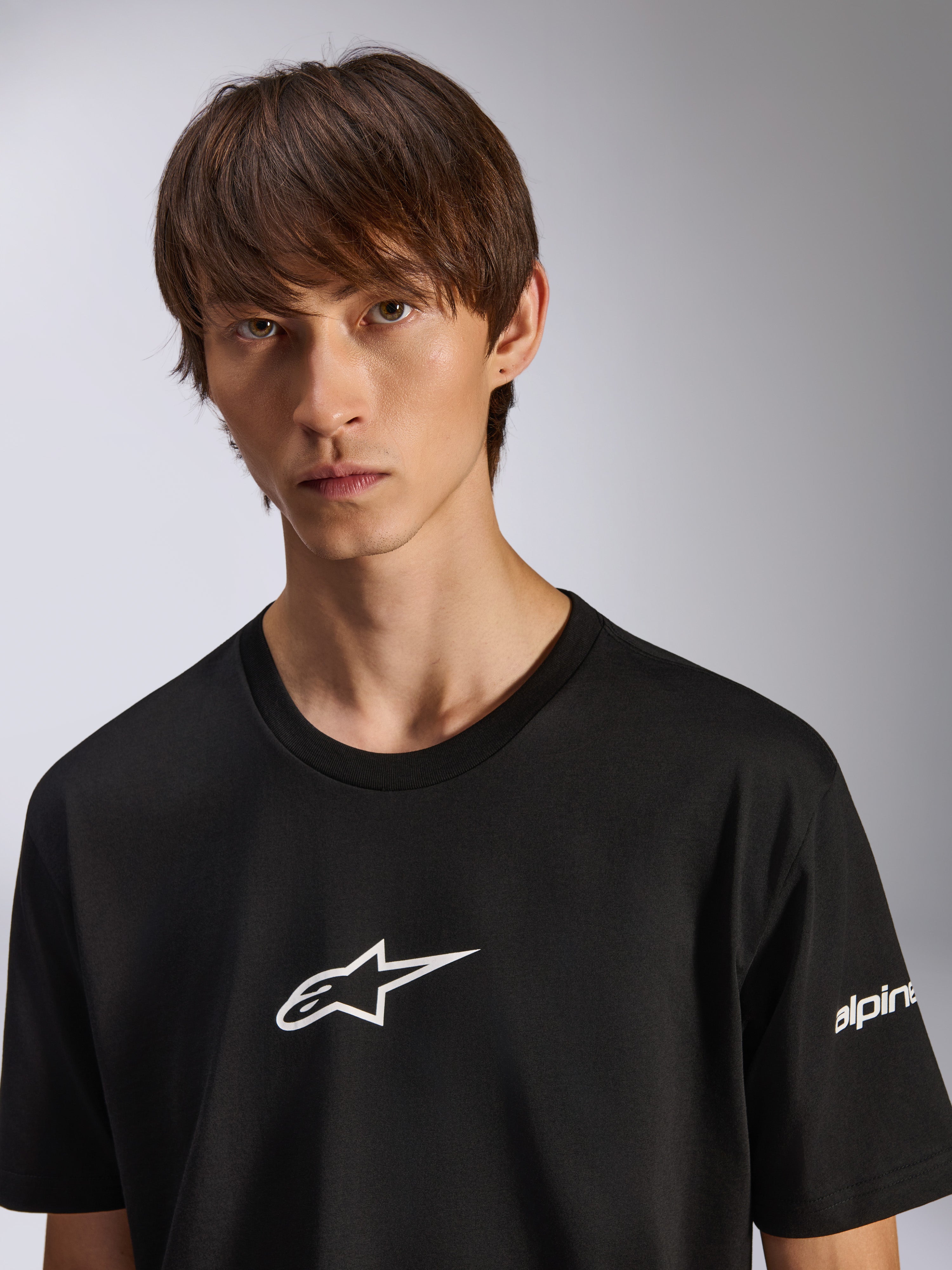 Alpinestars Frontal CSF Tee, maglietta a maniche corte, nera, logo Astars bianco sul petto, indossata da un modello maschile, abbigliamento sportivo casual ad alte prestazioni