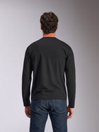 Alpinestars Trackside CSF Tee, maglia a maniche lunghe, nera, vista posteriore, indossata con jeans in denim blu scuro, streetwear casual ispirato al motorsport