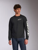 Alpinestars Trackside CSF Long Sleeve Tee, maglia a maniche lunghe nera, logo Alpinestars bianco sul petto e marchio sulla manica, indossata da un modello con jeans blu, streetwear casual motorsport
