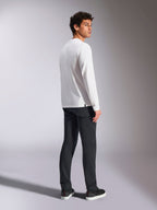 Alpinestars Trackside CSF Tee, maglietta a maniche lunghe, bianca, modello maschile visto di spalle con pantaloni neri, abbigliamento casual streetwear ispirato al motorsport
