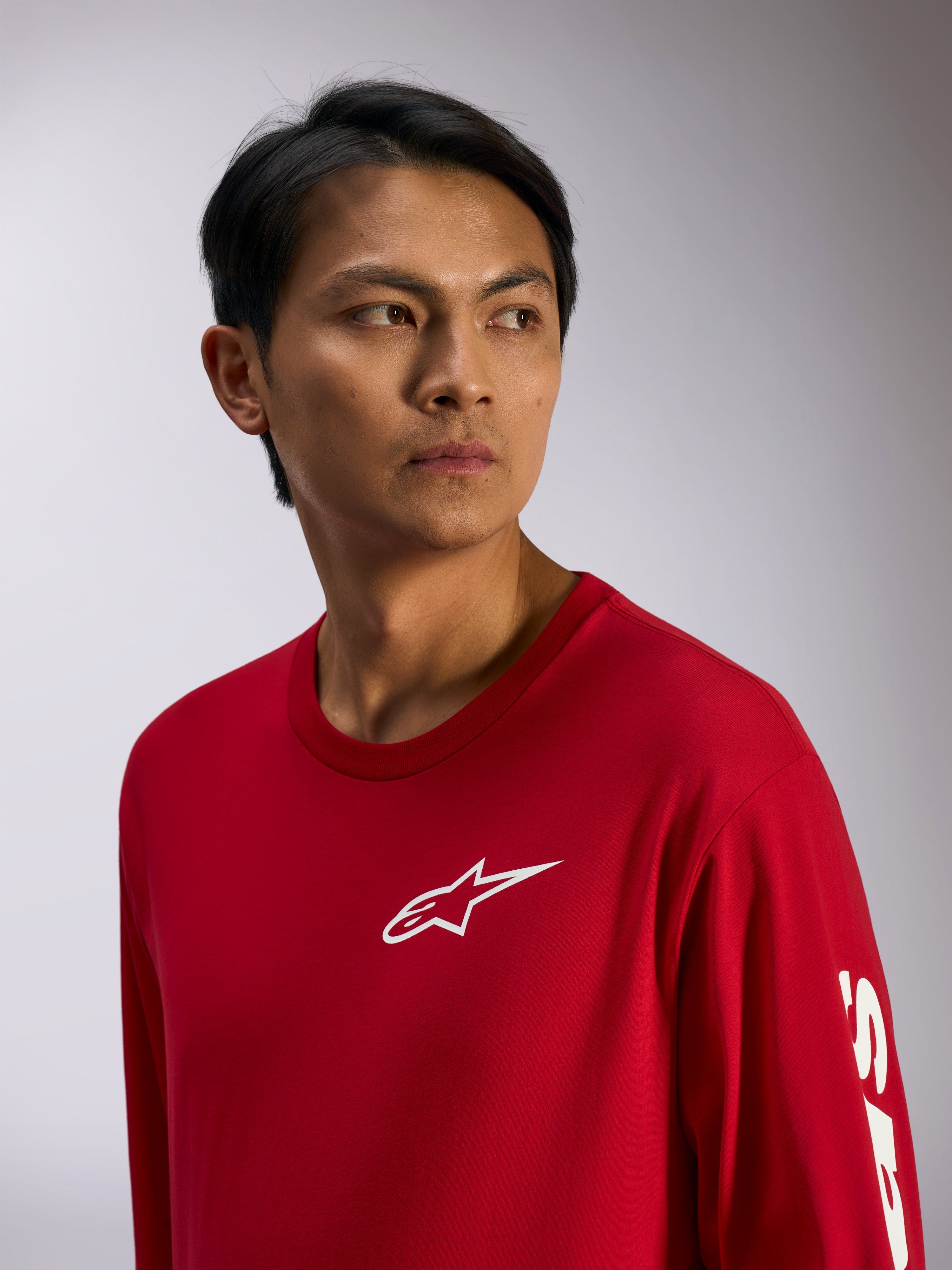 Alpinestars Trackside CSF Tee, t-shirt a maniche lunghe, rossa con logo Alpinestars bianco sul petto e scritta sulla manica, streetwear casual motorsport, ritratto lifestyle