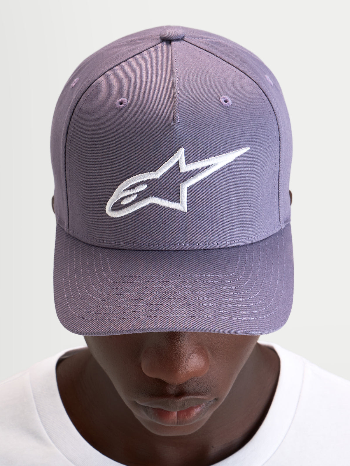 Alpinestars Cappello Ageless Snapback, cappello sportswear casual in viola e bianco, con visiera curva, corona strutturata e logo Astars ricamato in 3D sul davanti, indossato da un modello