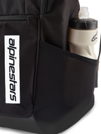 Zaino Alpinestars Defcon V3, zaino giornaliero nero, primo piano della tasca laterale in rete con borraccia, logo verticale bianco sulla parte anteriore, materiale in poliestere 600D resistente