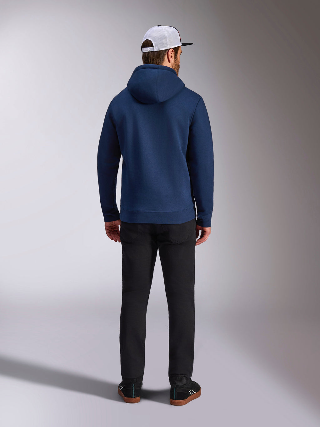 Alpinestars Felpa con Cappuccio Frontal, Blu Navy, vista posteriore di un uomo che indossa una felpa casual in pile, con polsini e orlo a coste, abbinata a pantaloni neri e un berretto in mesh bianco, streetwear ispirato al motorsport