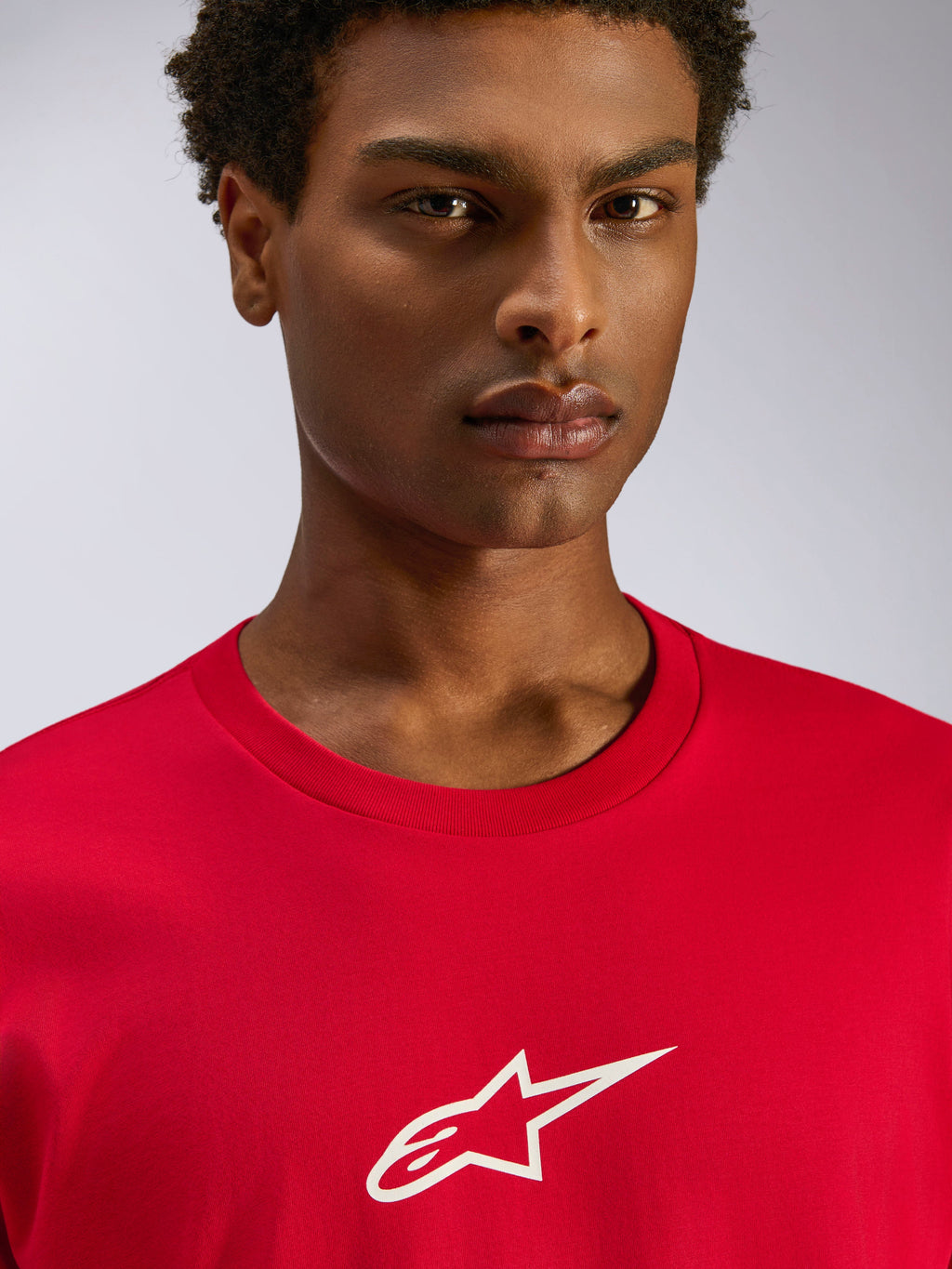 Alpinestars Frontal CSF Tee, t-shirt a maniche corte, rosso, logo Astars bianco sul petto, primo piano di un modello che indossa abbigliamento sportivo sostenibile e traspirante