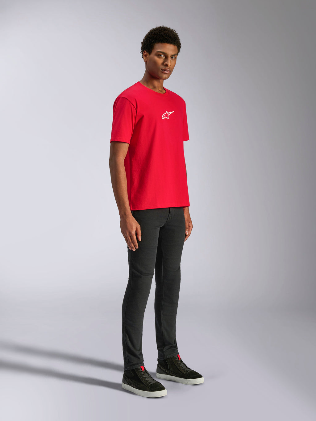 Alpinestars Frontal CSF Tee, t-shirt a maniche corte, rossa, logo con stella bianca sul petto, indossata da un modello con pantaloni neri e sneakers nere, streetwear casual performance motorsport