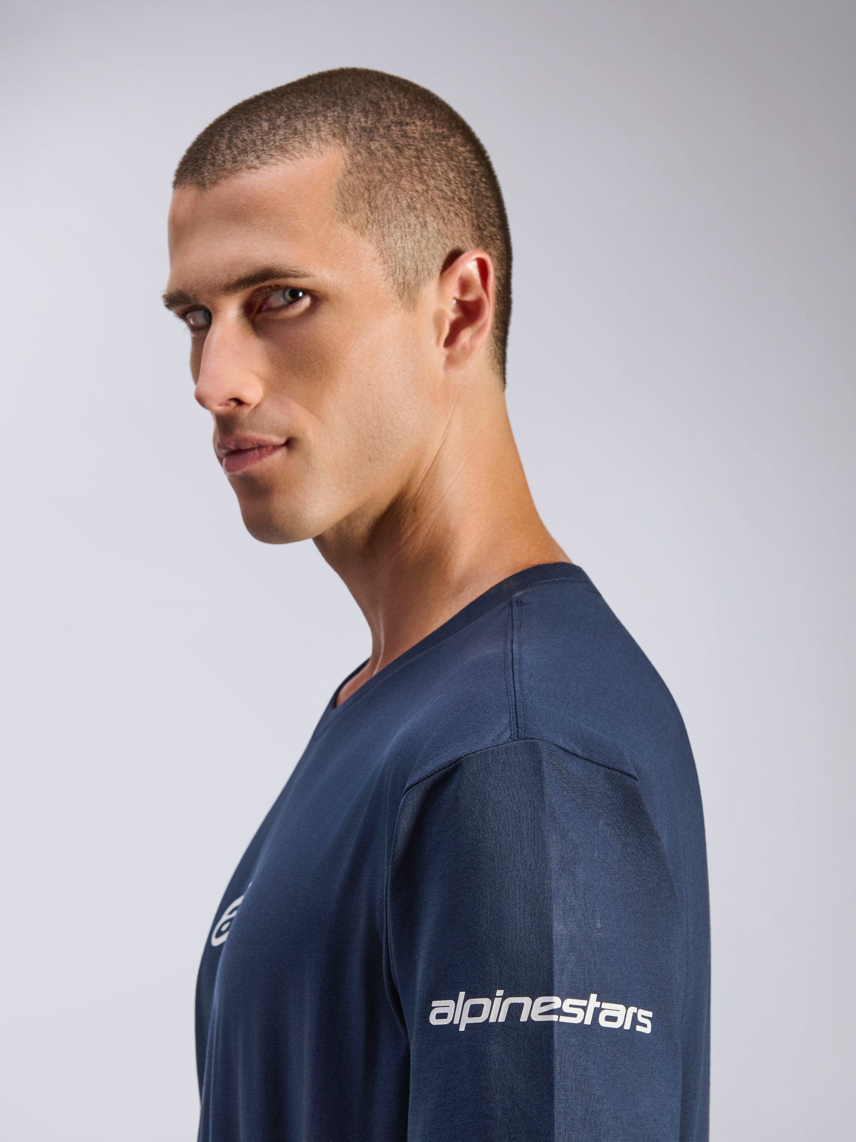 Alpinestars Frontal CSF Tee, T-shirt a maniche corte, blu navy, vista di profilo di un modello, logo Alpinestars bianco sulla manica, tessuto tecnico traspirante, stile casual motorsport