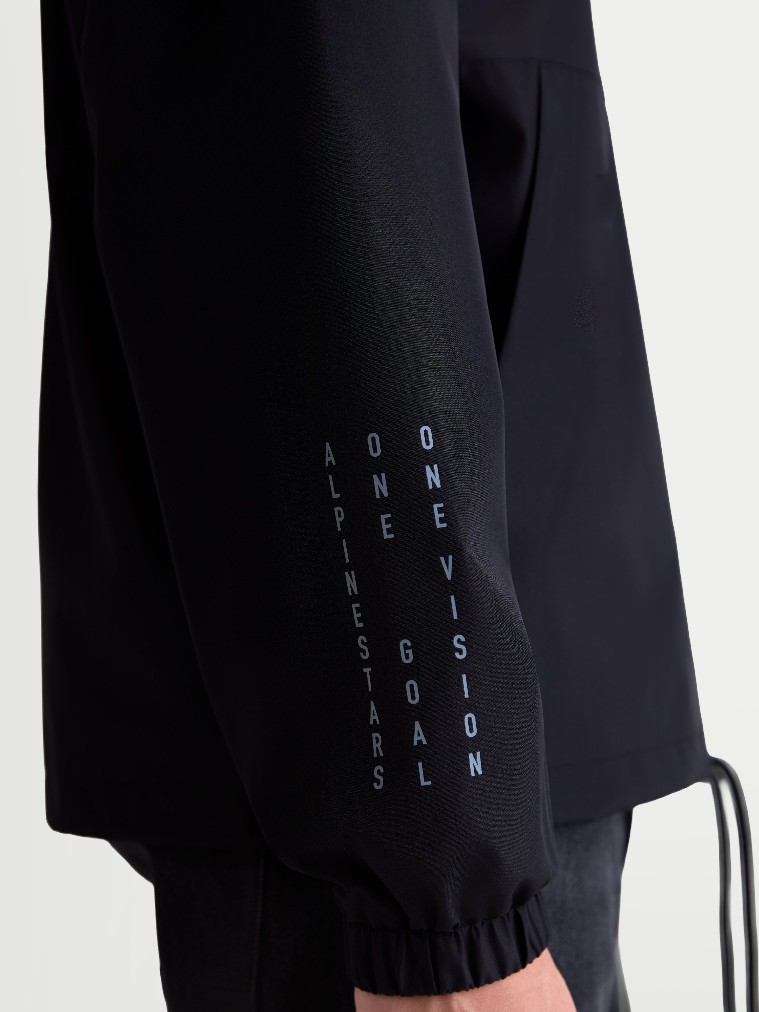 Alpinestars Giacca Frangivento Speeder Resolve, giacca sportswear leggera, nera, dettaglio della manica con branding verticale e polsino elastico, costruzione frangivento in 100% poliestere per uso urbano