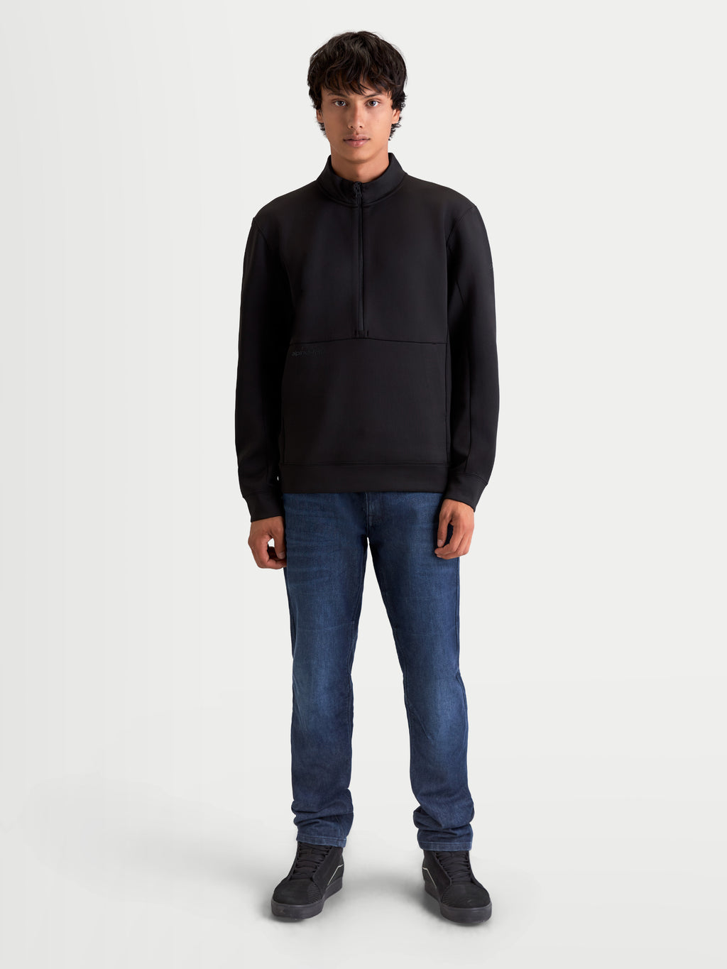 Alpinestars Felpa Apera Half-Zip, pullover sportswear da uomo con chiusura a mezza zip e tasca a marsupio, nero, branding tonale e stile ispirato al motorsport, indossata da un modello.