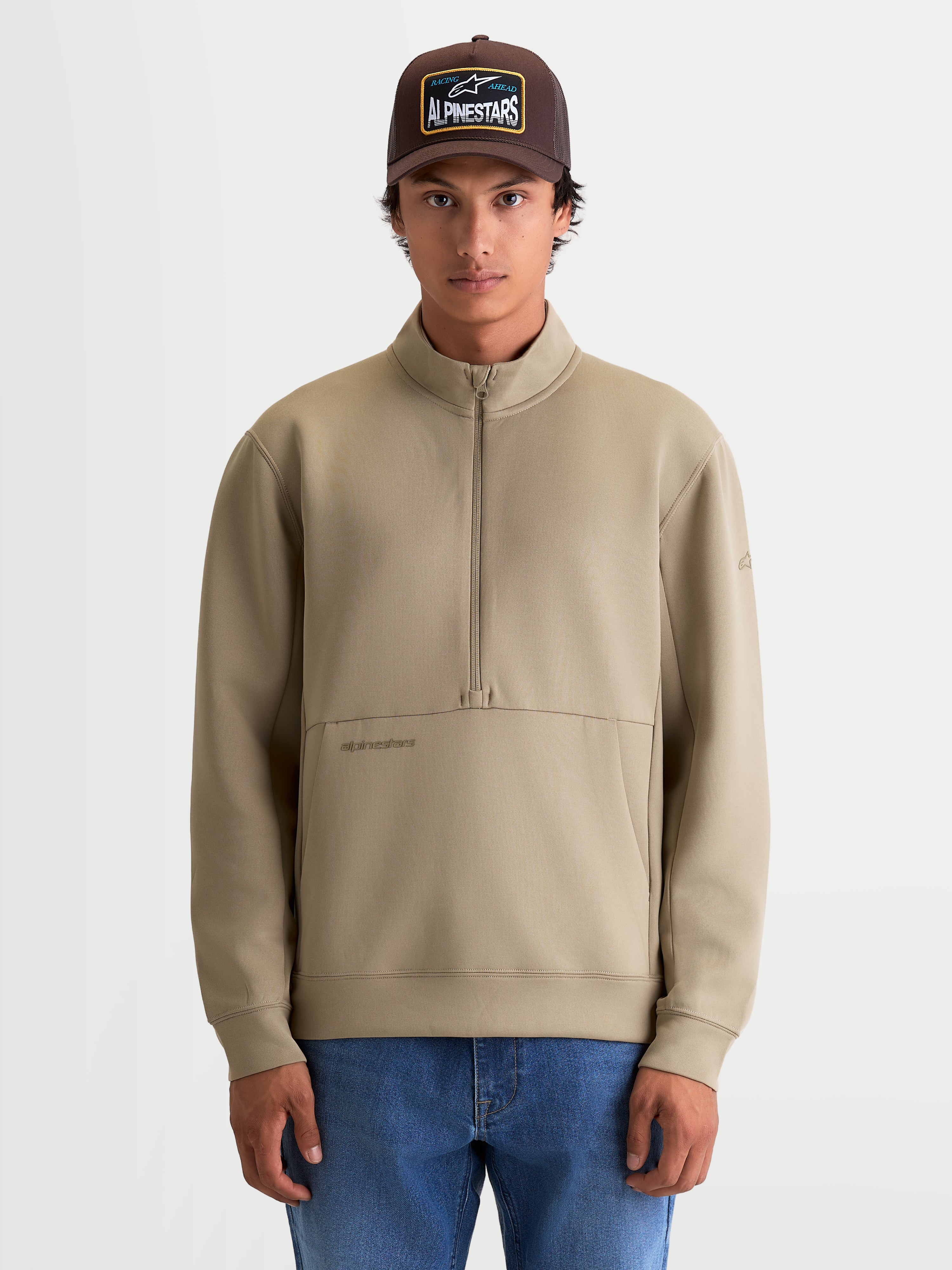 Alpinestars Felpa Apera Half-Zip, felpa sportiva casual da uomo, beige, chiusura con mezza zip, tasca a marsupio frontale e logo HD tonale, realizzata in pile tri-blend, indossata da un modello.