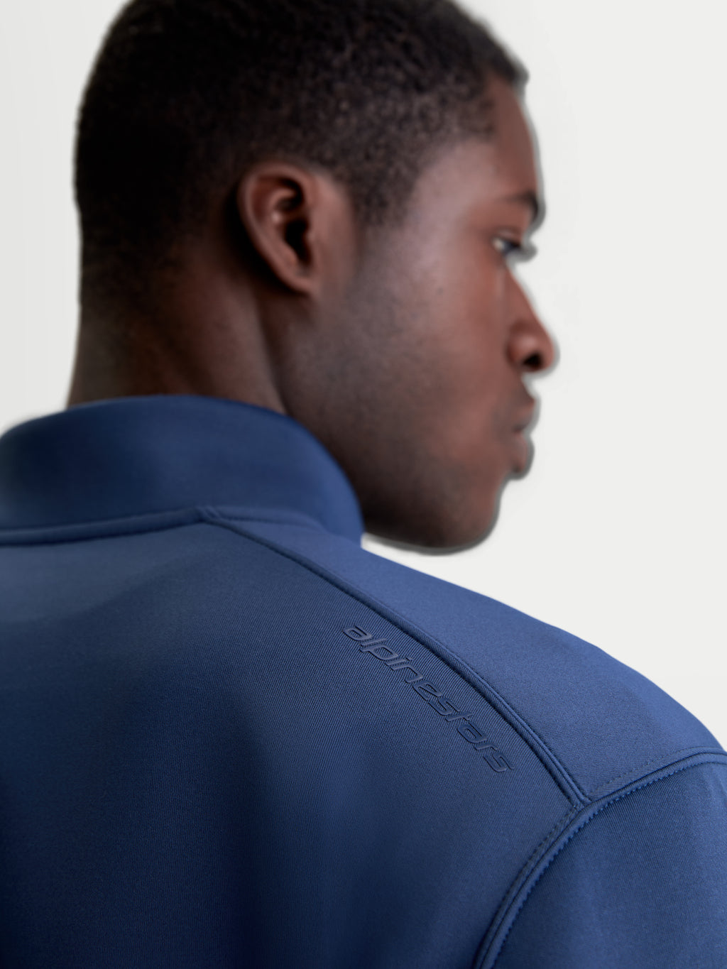 Alpinestars Felpa Apera Half-Zip, felpa sportswear blu, vista posteriore ravvicinata su modello con stampa logo HD tonale sulla spalla, tessuto in pile tri-blend premium, stile casual motorsport