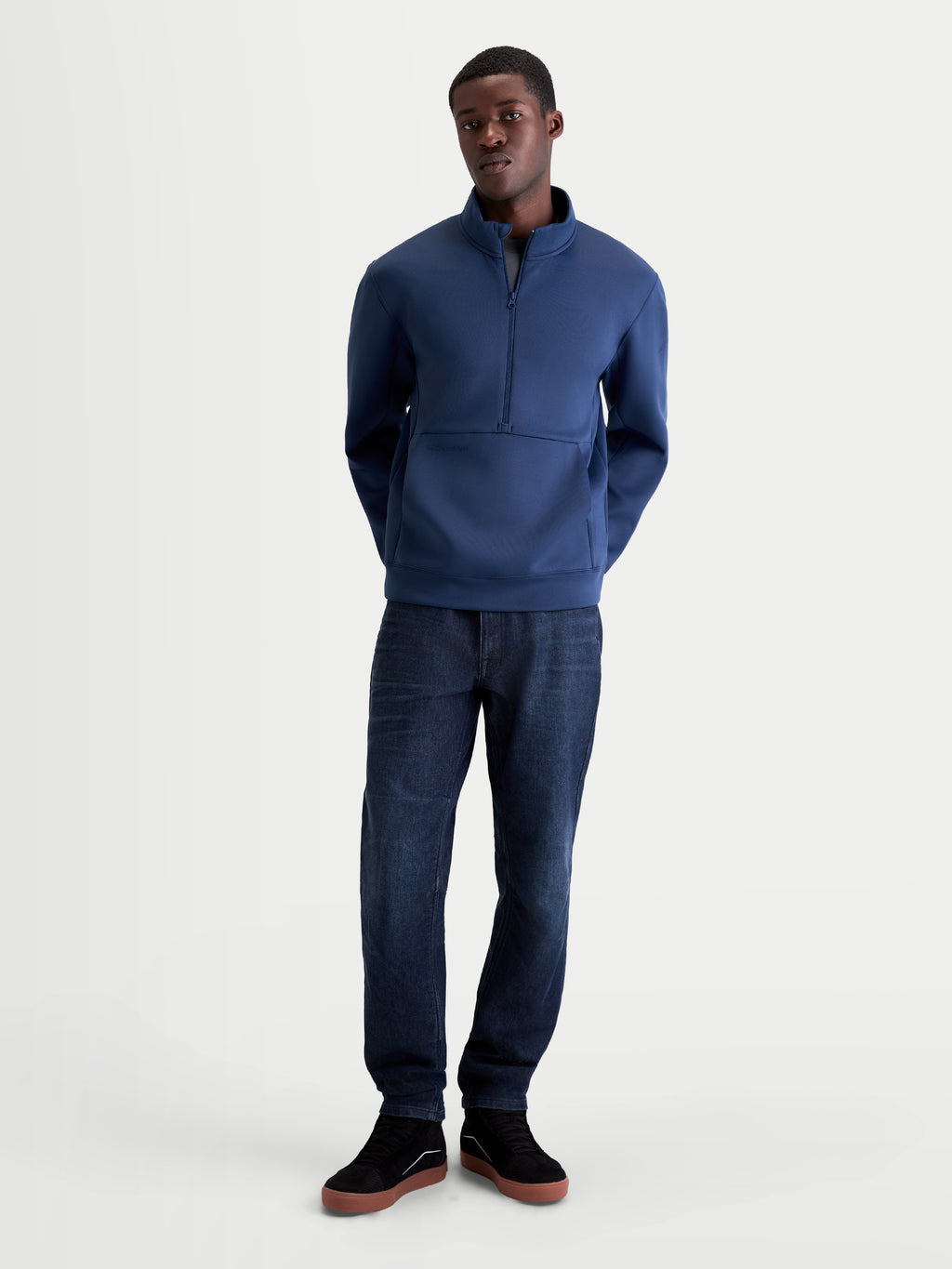 Alpinestars Felpa Apera Half-Zip, felpa da uomo in pile tri-blend, blu acciaio, chiusura frontale half-zip, tasca a marsupio e colletto alto, indossata da un modello, stile casual ispirato al motorsport