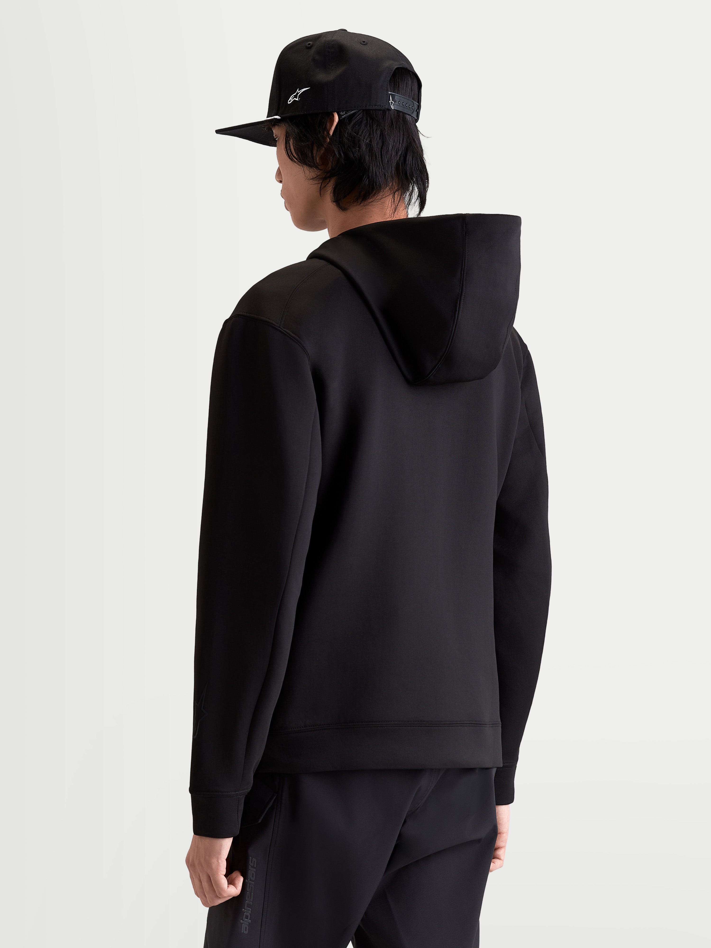 Alpinestars felpa con cappuccio Datrix, pullover sportswear da uomo, nera, vista posteriore su modello con cappuccio foderato in rete e costruzione in pile double-face, comfort casual e stile ispirato al motorsport