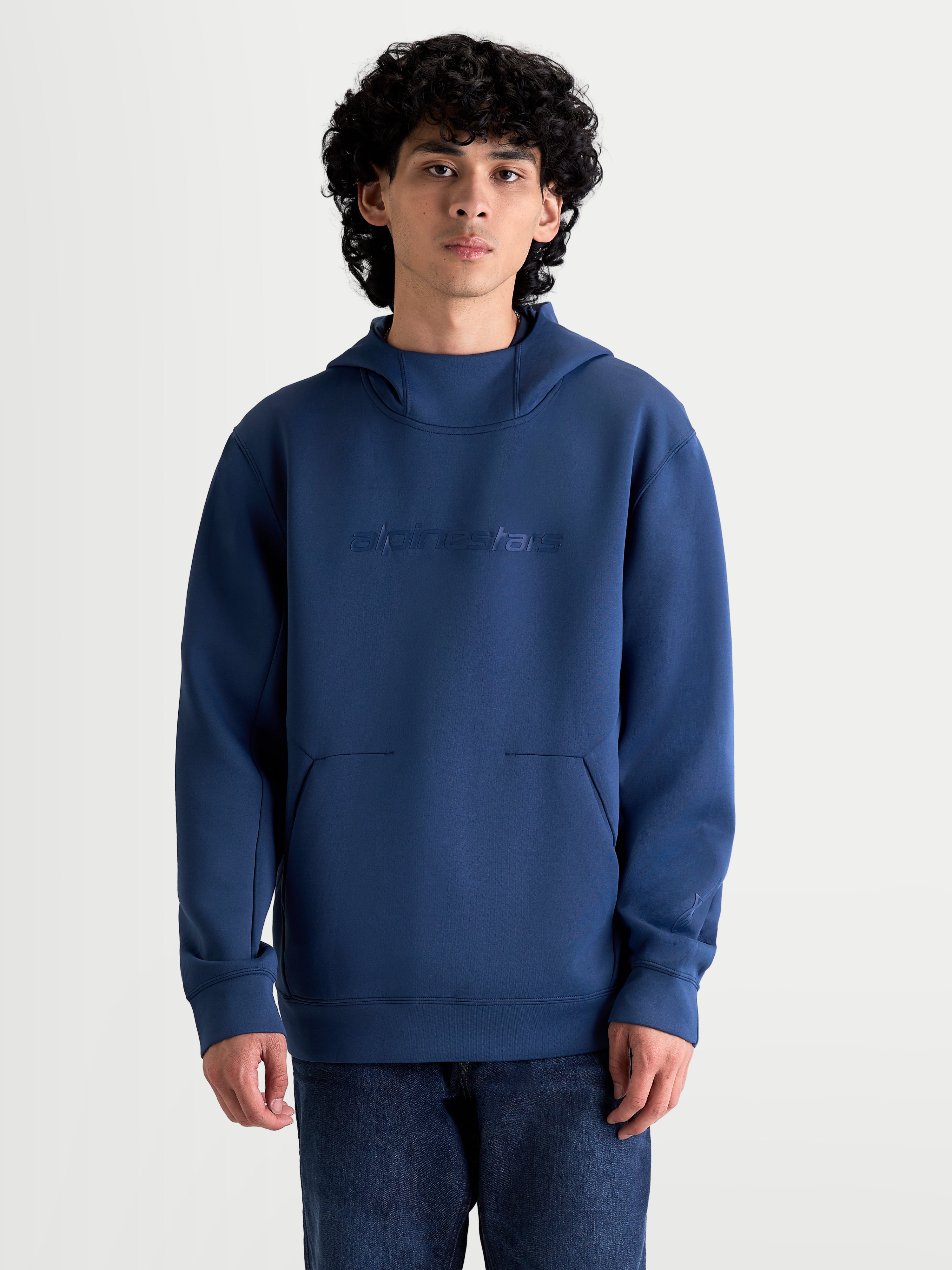 Alpinestars Felpa con cappuccio Datrix, felpa sportswear da uomo, blu, branding HD tono su tono sul petto, cappuccio foderato in rete e tasca frontale con dettaglio a freccia, stile ispirato al motorsport, indossata da un modello.