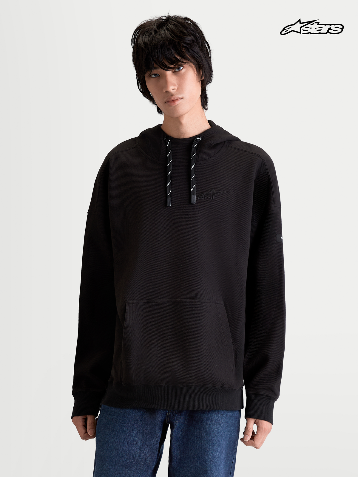 Alpinestars Felpa Con Cappuccio Camino Textured Oversize, felpa sportswear con cappuccio da uomo, nera, in pile di twill testurizzato con tasca a marsupio e collo alto, indossata da un modello