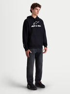Alpinestars Felpa con cappuccio Prelude Oversized, felpa sportswear da uomo in pile, nera con logo bianco a rilievo sul petto, vestibilità oversize e tasca a marsupio, indossata da un modello