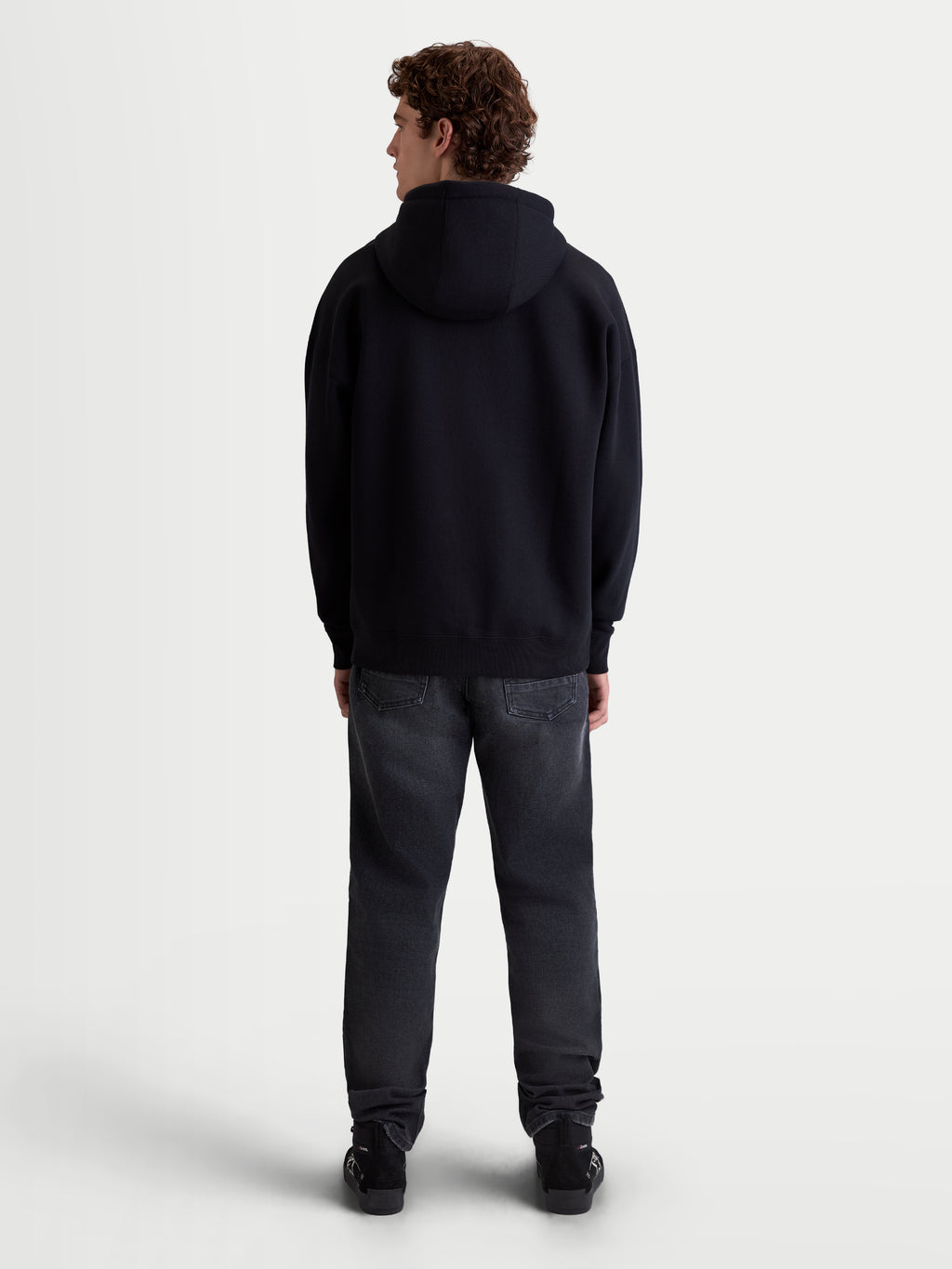 Alpinestars Felpa con cappuccio Prelude Oversized, felpa sportswear da uomo, vista posteriore su modello, nera, vestibilità oversize rilassata, spalle scese e orlo a costine, abbigliamento casual quotidiano