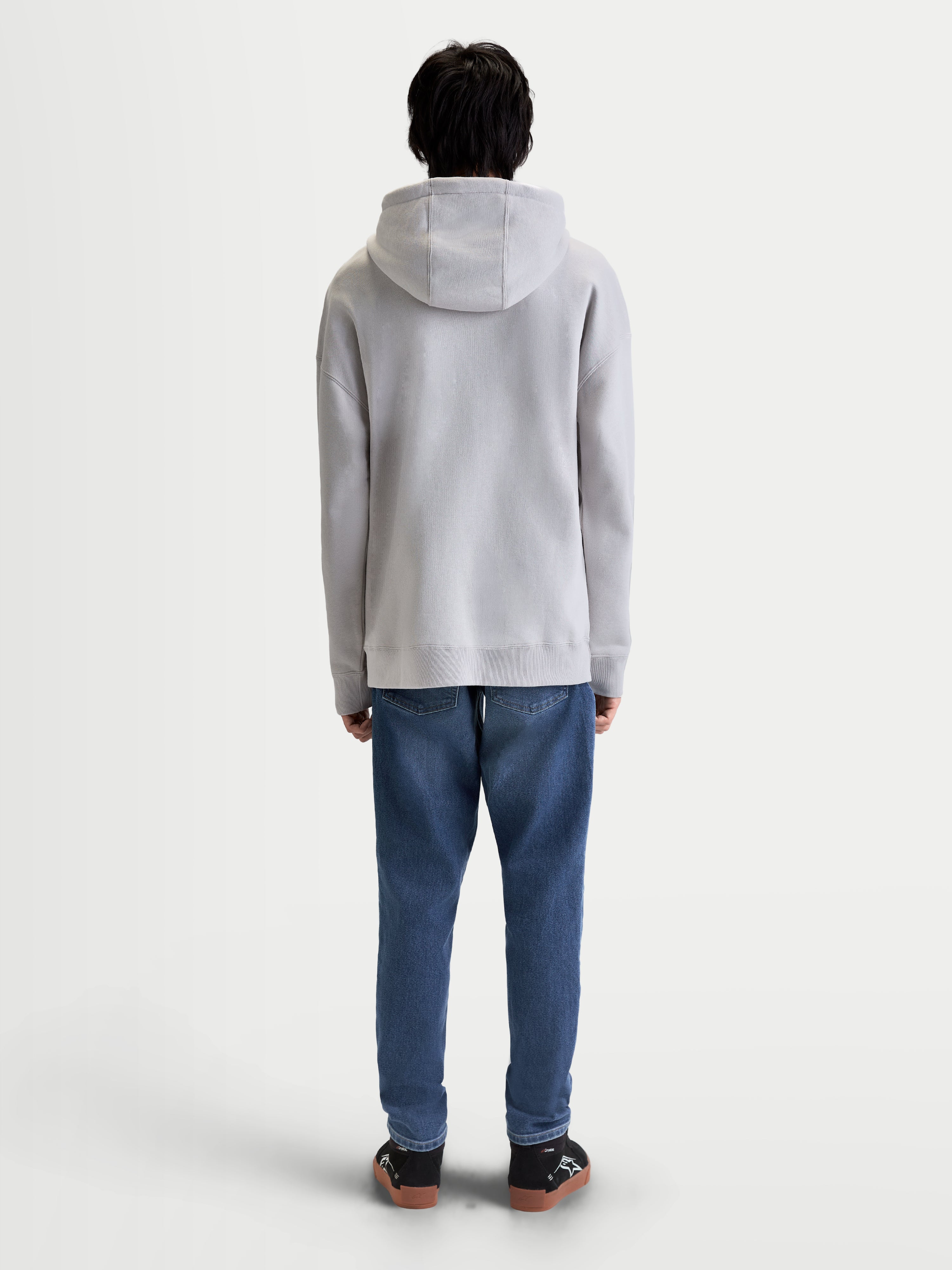 Alpinestars felpa con cappuccio Prelude Oversized, felpa sportswear da uomo grigio cemento, vista posteriore su modello con vestibilità rilassata, cappuccio foderato, polsini e orlo a costine