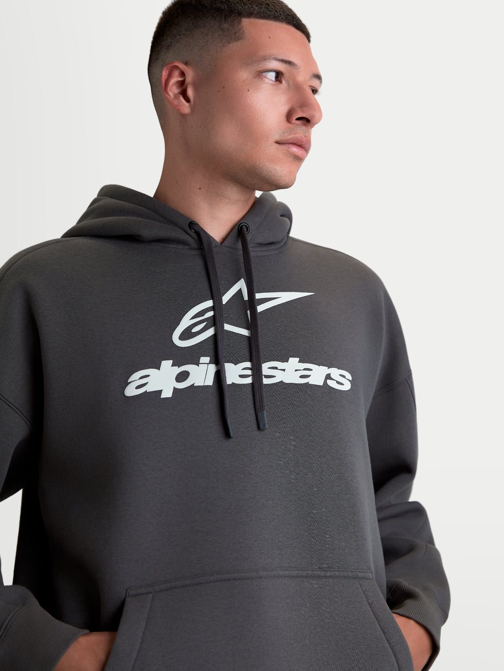 Alpinestars Felpa con cappuccio Prelude Oversized, felpa sportswear unisex, grigio antracite con logo bianco in stampa a rilievo, vestibilità oversize, con tasca a marsupio e cappuccio regolabile.