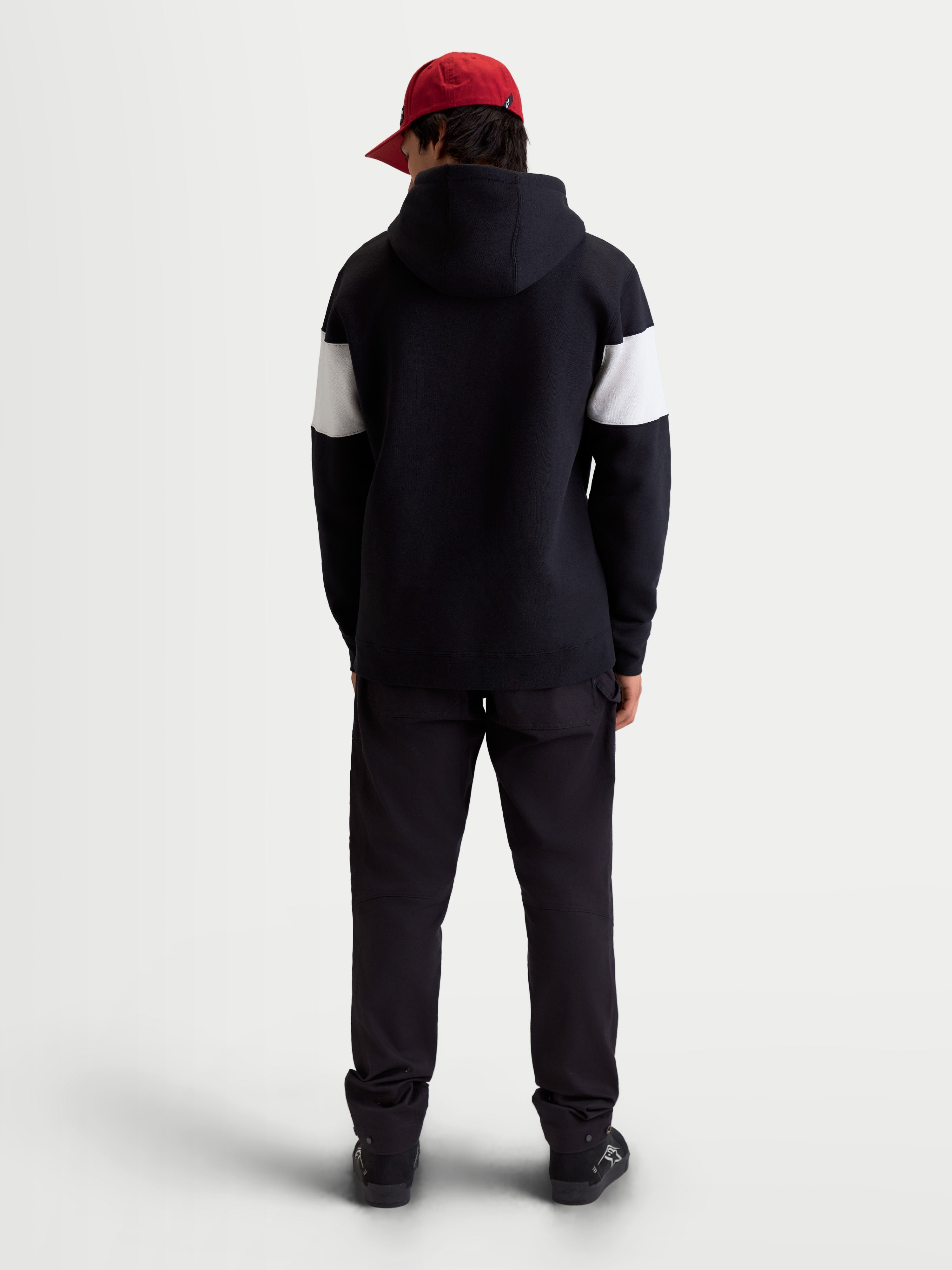 Alpinestars Felpa con cappuccio Cubic, felpa sportswear in pile unisex, nero e bianco, vista posteriore su modello, design color block sulle maniche, abbigliamento casual motorsport in misto cotone.