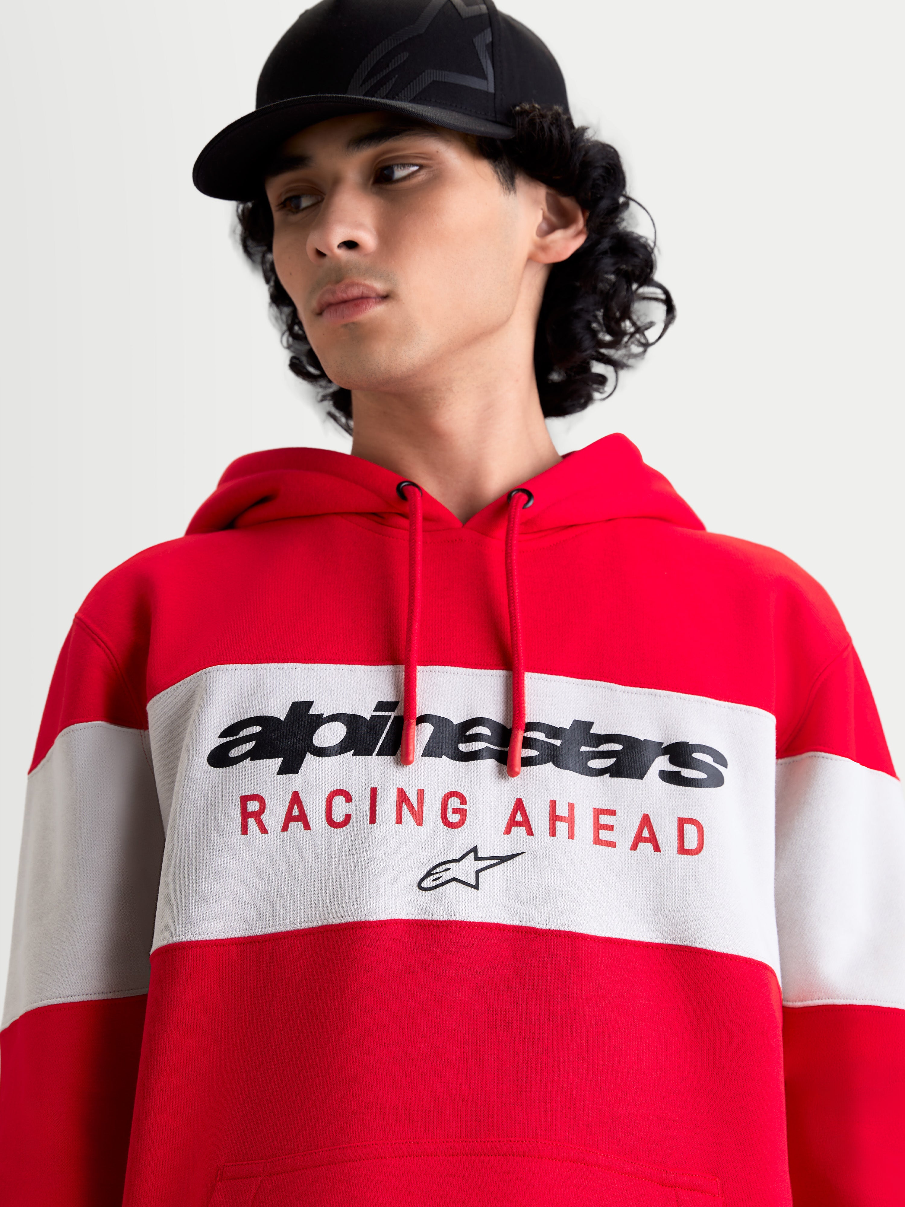 Alpinestars Felpa con cappuccio Cubic, felpa sportswear unisex, rosso e bianco, design a blocchi di colore con logo frontale Alpinestars e grafica 'RACING AHEAD', in cotone e poliestere riciclato, vista su modello
