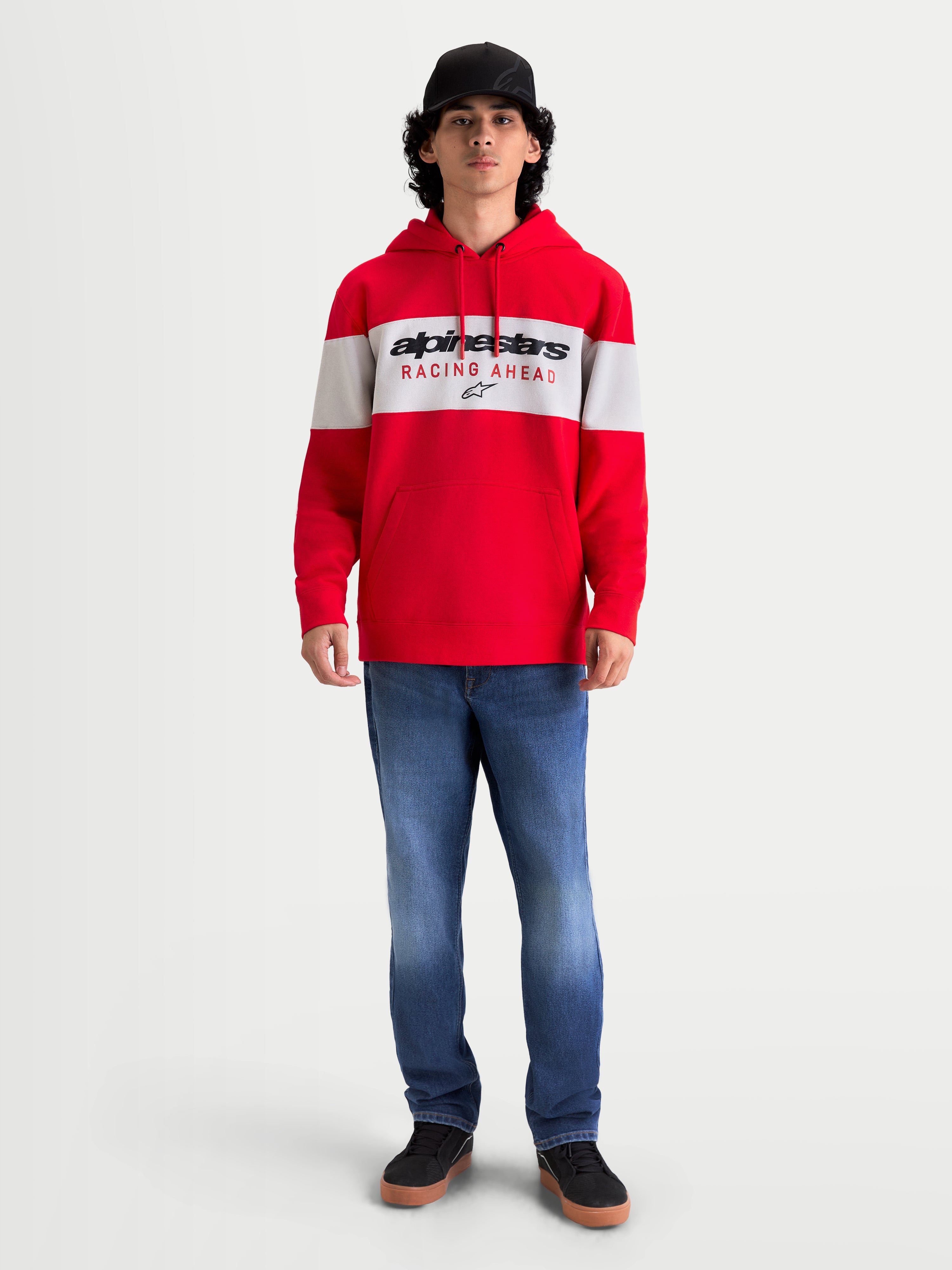 Alpinestars felpa con cappuccio Cubic, felpa sportswear da uomo, rossa e bianca, design a blocchi di colore con logo Alpinestars Racing Ahead sul petto. Vista su modello che mostra una vestibilità casual ispirata al motorsport con cappuccio e cordini, ideale per lo stile off-bike.