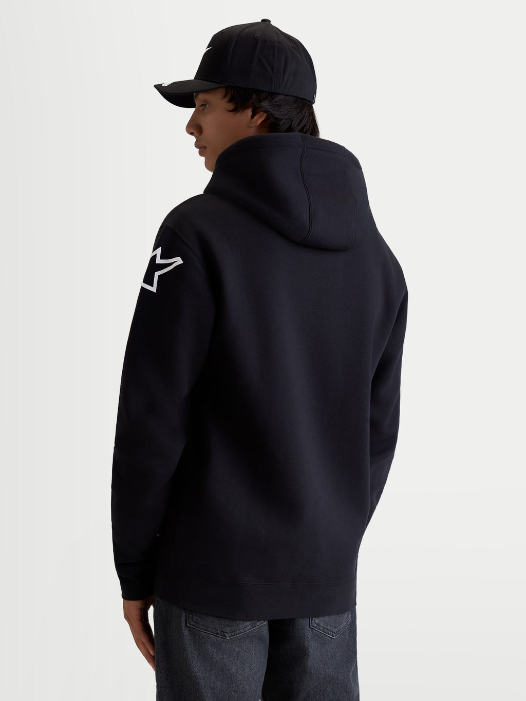 Alpinestars felpa con cappuccio Velocifier, felpa da uomo in pile nera con logo Astars bianco sulla spalla, cappuccio foderato e polsini a coste, vista posteriore su modello, abbigliamento casual motorsport, in cotone e poliestere riciclato