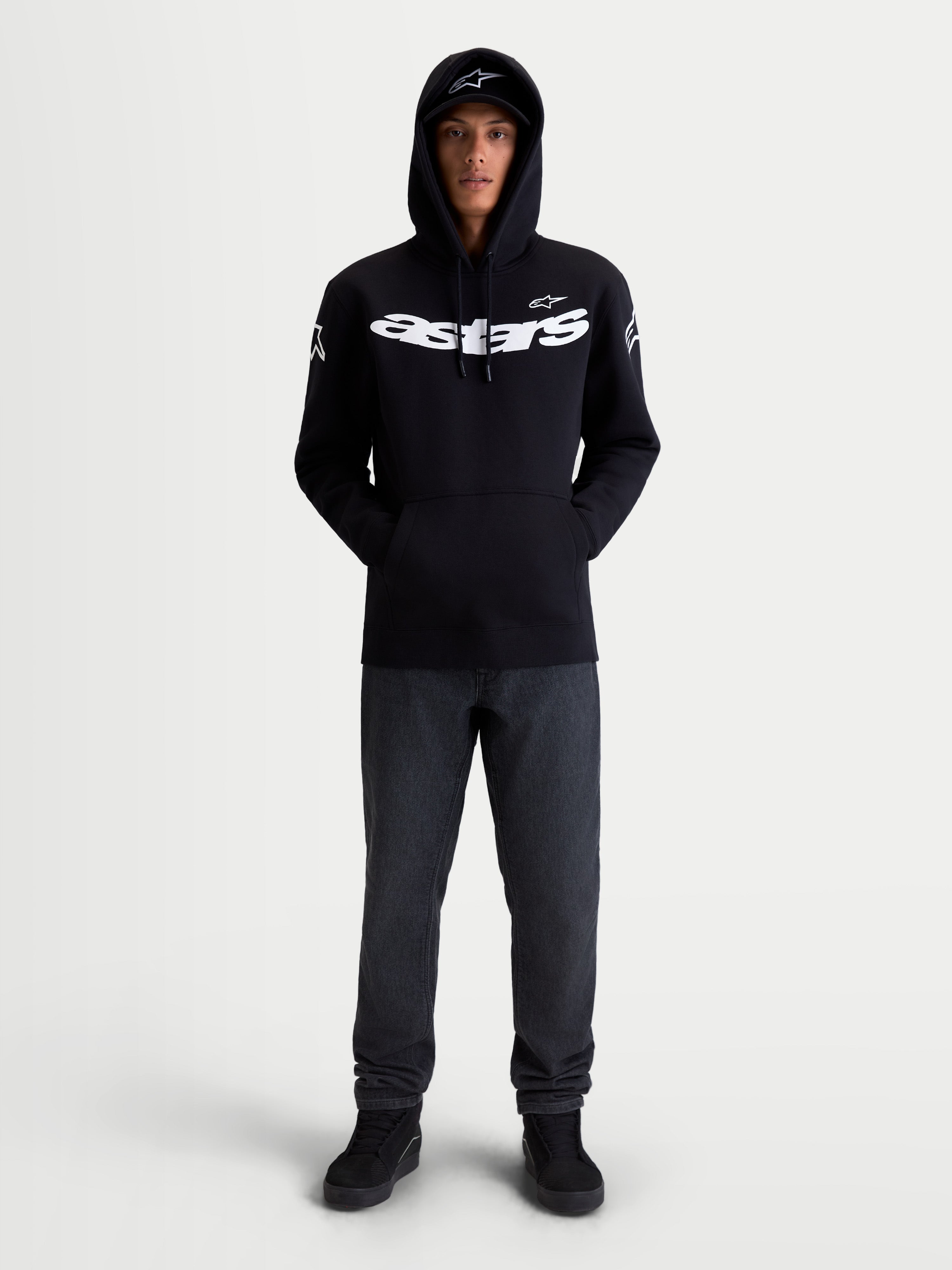 Alpinestars Felpa con cappuccio Velocifier, pullover in pile da sportswear da moto unisex, nera e bianca, in misto cotone e poliestere riciclato, con grande scritta Astars sul petto e loghi sulle spalle, vista frontale su modello per abbigliamento casual off-bike.