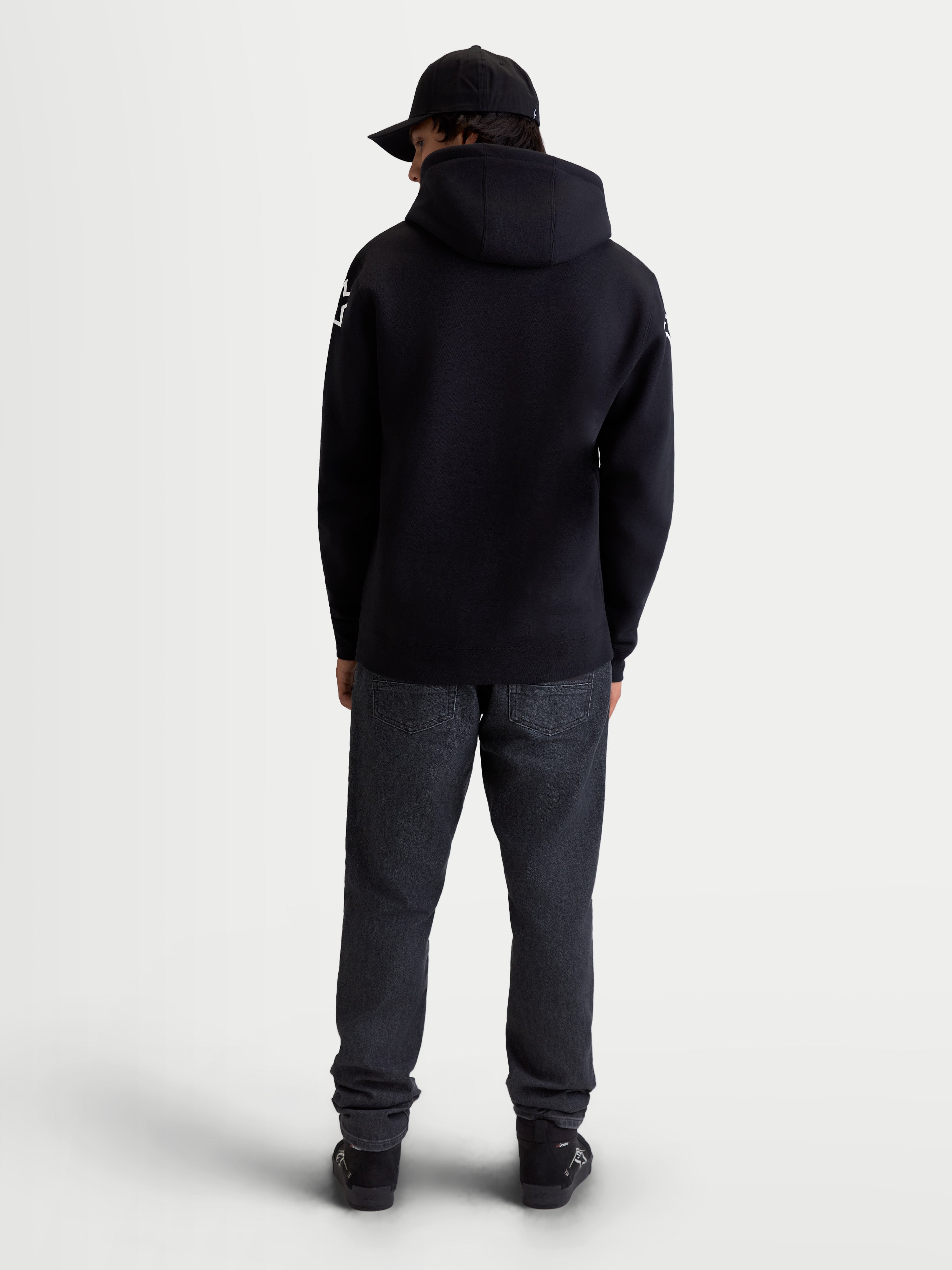 Alpinestars Felpa con cappuccio Velocifier, pile pullover da uomo sportswear, nera, vista posteriore su modello con loghi Alpinestars bianchi sulle spalle, misto cotone e poliestere riciclato