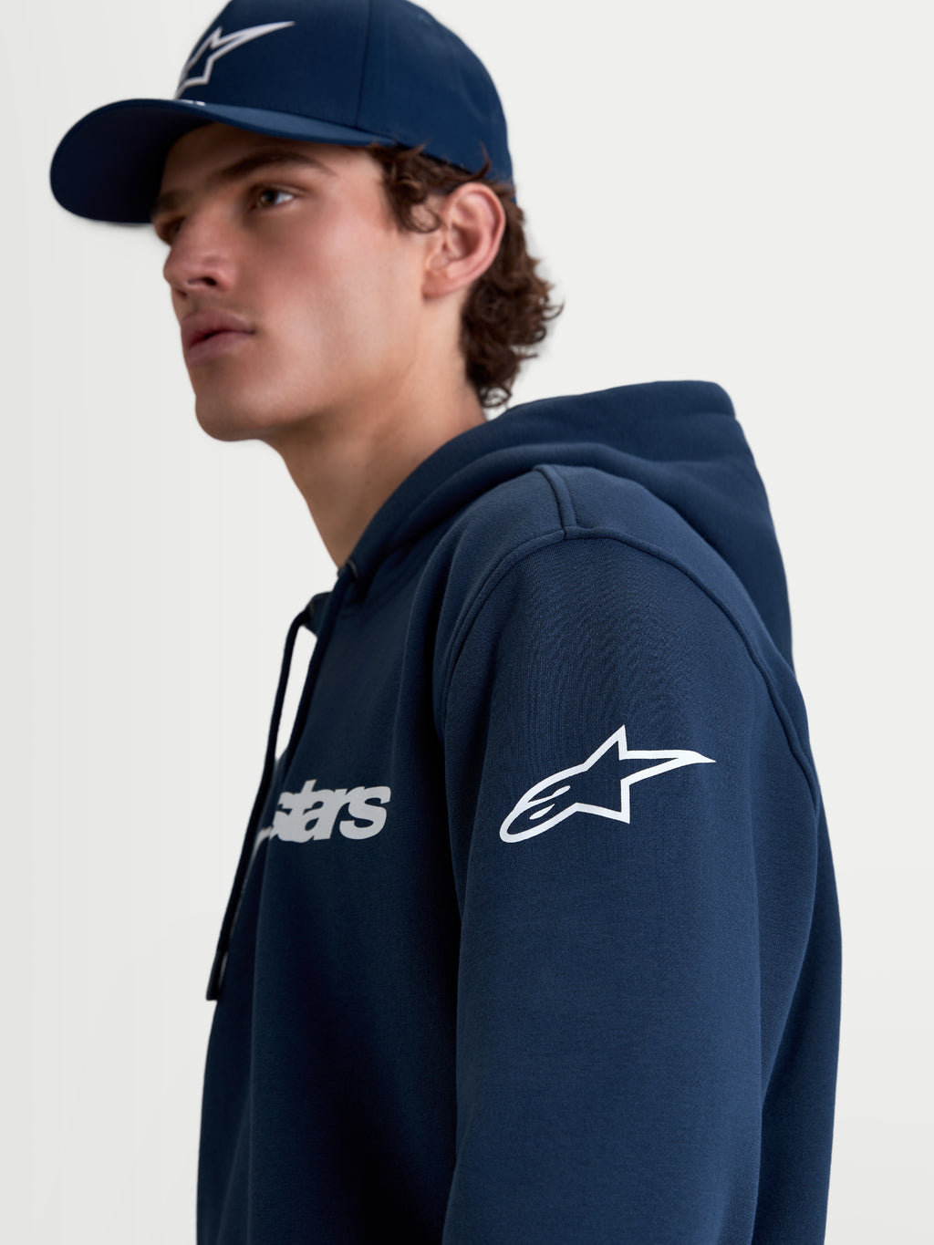 Alpinestars Felpa con cappuccio Race Wordmark, felpa in pile sportswear da uomo, blu navy e bianco, con logo Ageless bianco sulla manica e grafica Race Wordmark sul petto, vista lifestyle su modello