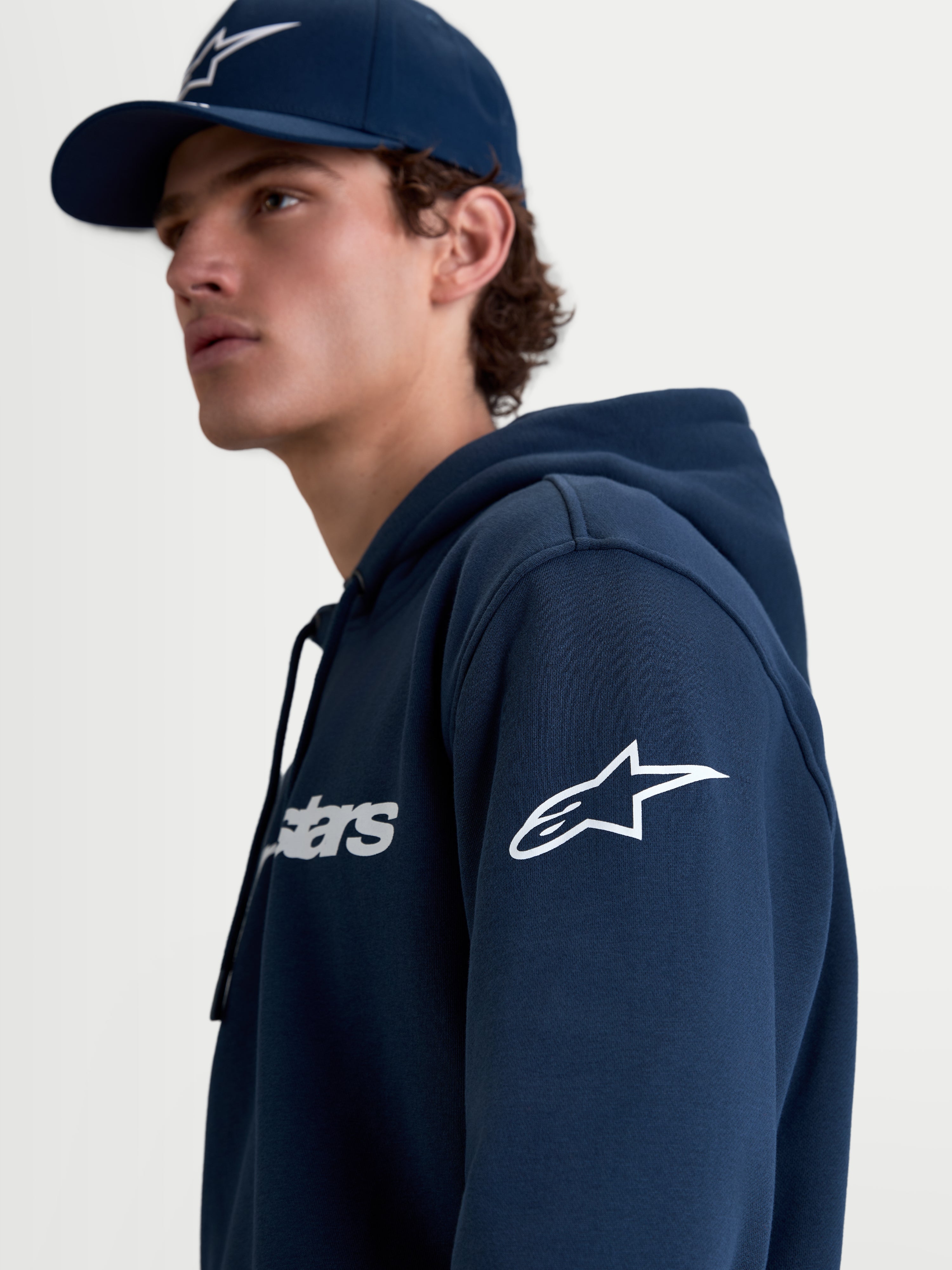 Alpinestars Felpa con cappuccio Race Wordmark, felpa in pile sportswear da uomo, blu navy e bianco, con logo Ageless bianco sulla manica e grafica Race Wordmark sul petto, vista lifestyle su modello