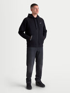 Alpinestars Felpa con cappuccio Pioneer Oversized, felpa da uomo sportswear con zip intera, nera, in misto cotone con cerniera Vislon e tasca a marsupio. Caratterizzata dal logo Astars bianco sul petto e scritta One Goal One Vision. Vista frontale su modello con vestibilità rilassata per abbigliamento casual.