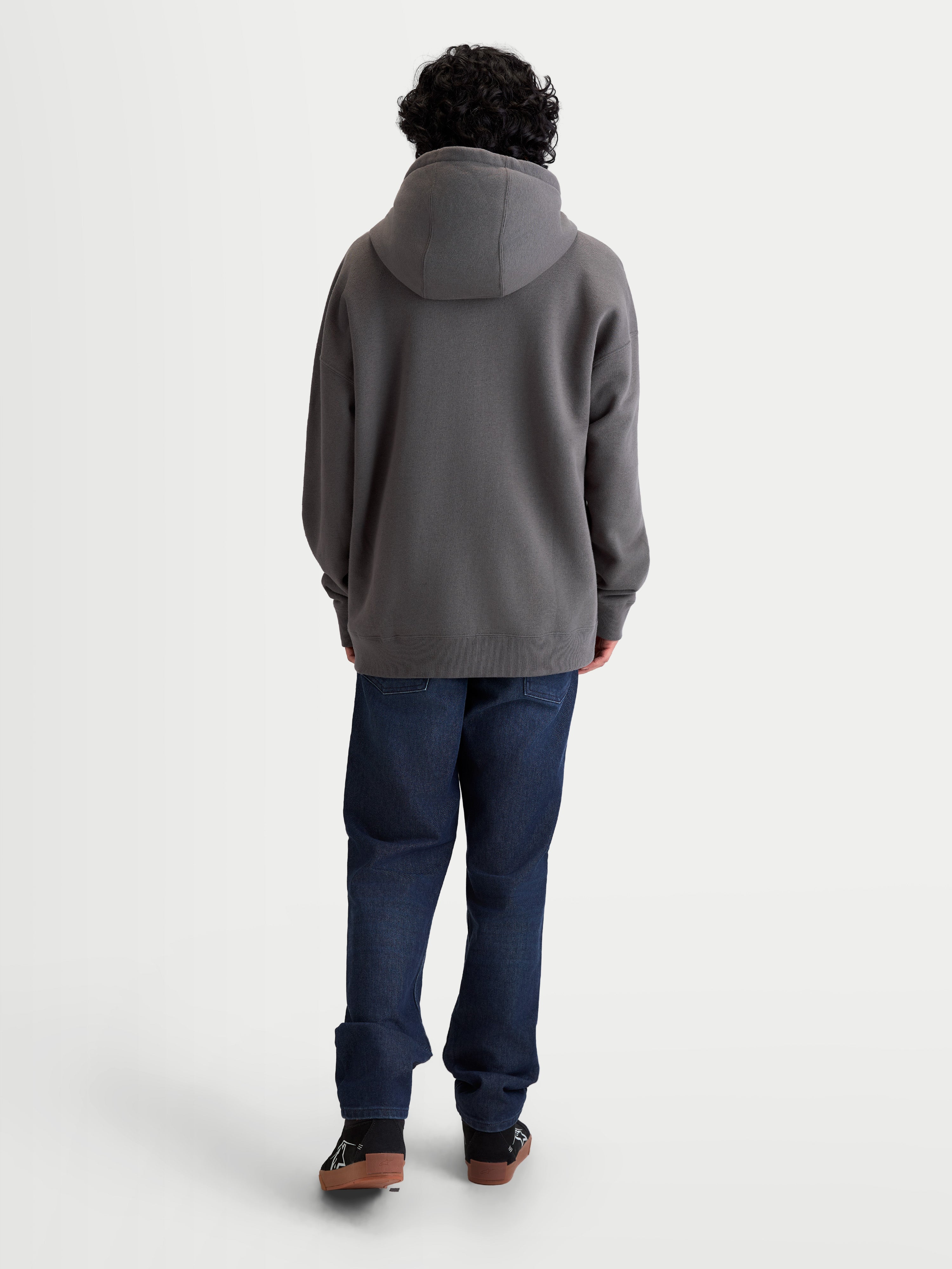 Alpinestars Felpa Con Cappuccio Entity Oversized, felpa con cappuccio unisex grigio antracite, vista posteriore su modello con vestibilità rilassata, cappuccio foderato e polsini a costine, misto cotone e poliestere riciclato, sportswear casual.