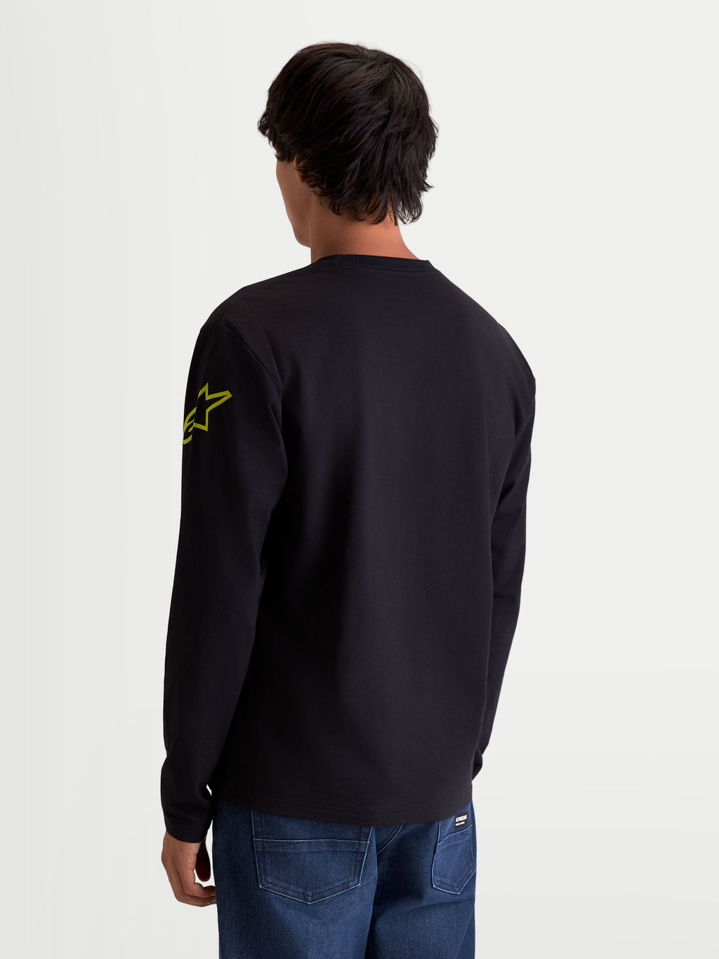 Alpinestars Maglietta Velocifier CSF, maglietta a maniche lunghe sportswear, unisex, nera e gialla, misto cotone e poliestere riciclato, vista posteriore su modello con logo Astars sul braccio e polsini a coste