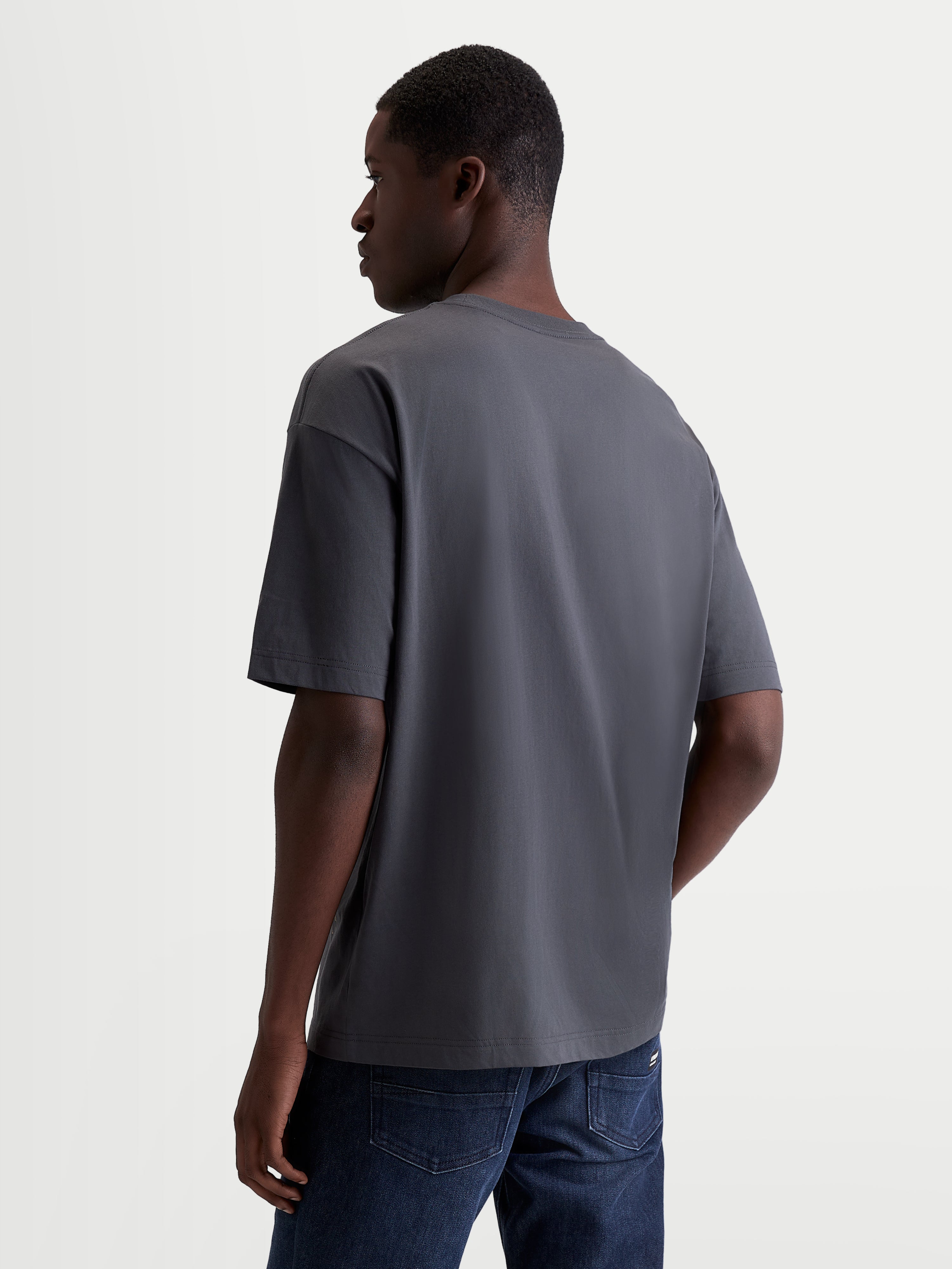 Alpinestars maglietta Chalk Oversized CSF, maglietta sportswear casual unisex, grigio carbone, vista posteriore di tre quarti su modello con vestibilità oversize e struttura in misto cotone e poliestere.
