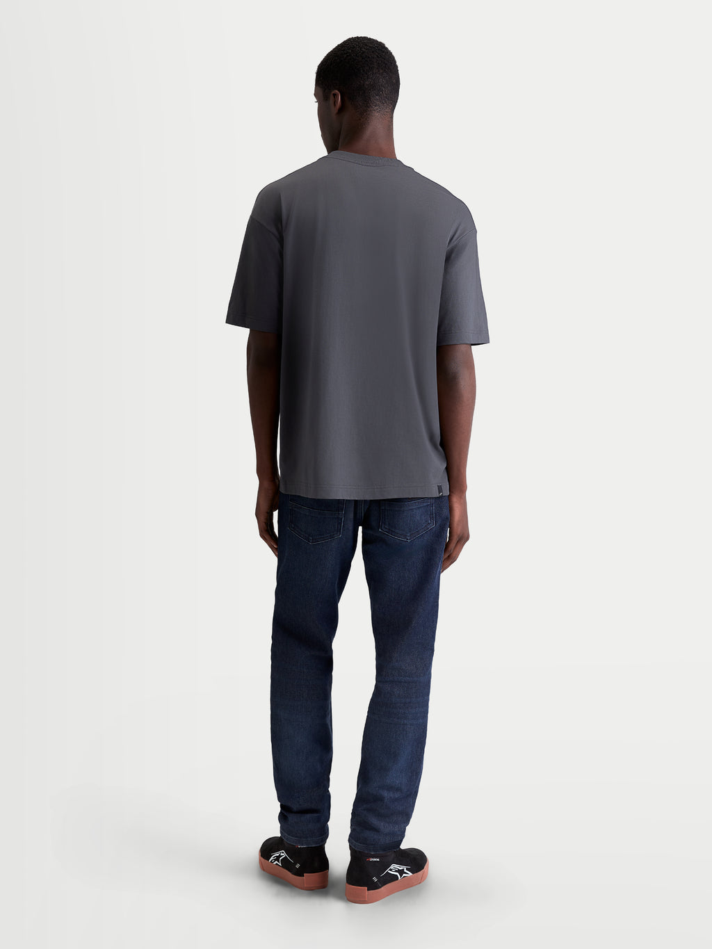 Alpinestars maglietta Chalk Oversized CSF, maglietta da uomo grigia scura, vestibilità oversize, vista posteriore su un modello, abbigliamento motorsport lifestyle.