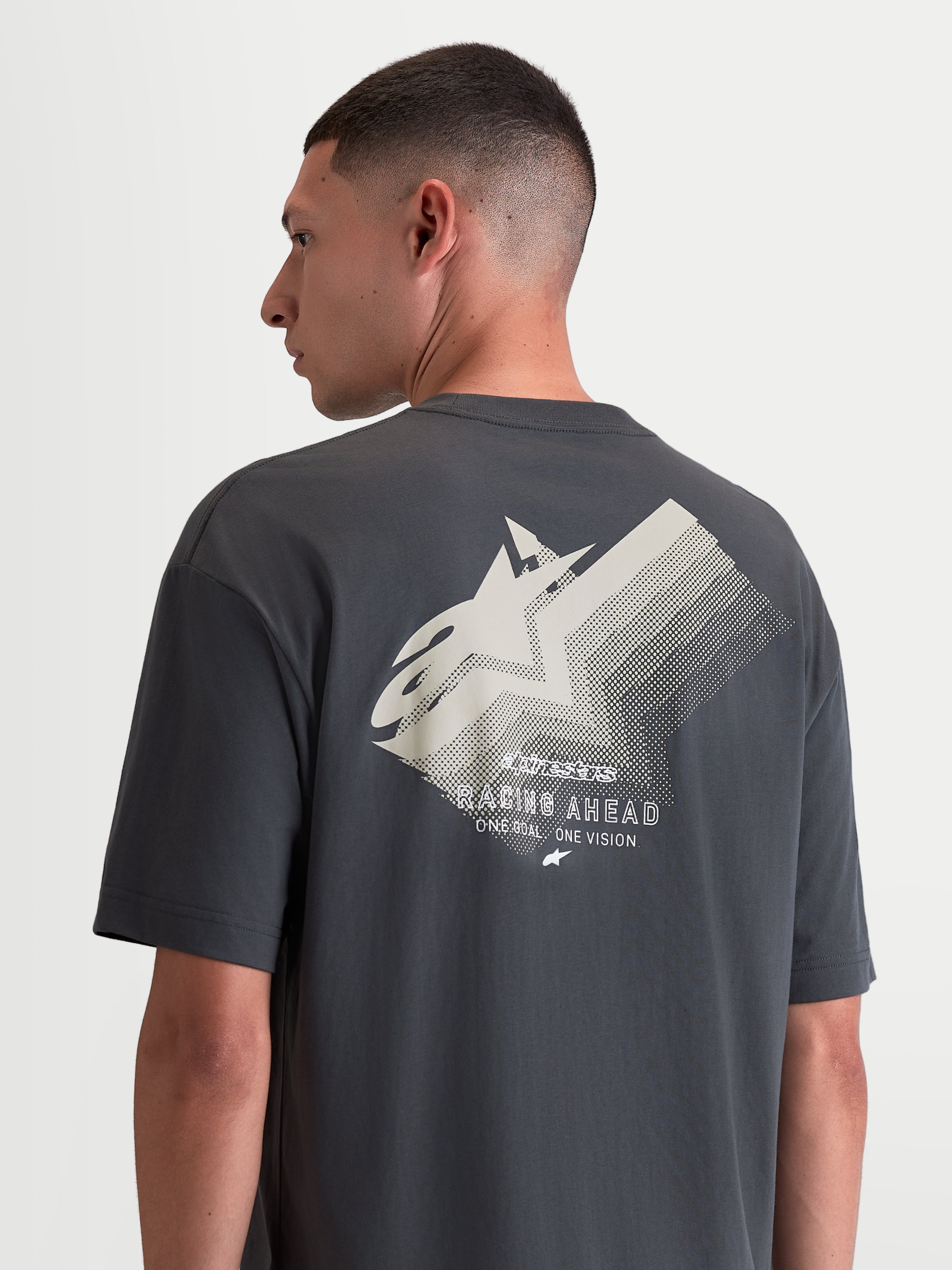 Alpinestars Maglietta Ghost Oversized CSF, maglietta a maniche corte sportswear unisex grigia, misto cotone-poliestere, vista posteriore con grande grafica bianca sfumata del logo Astars e scritta Racing Ahead, vestibilità rilassata oversize